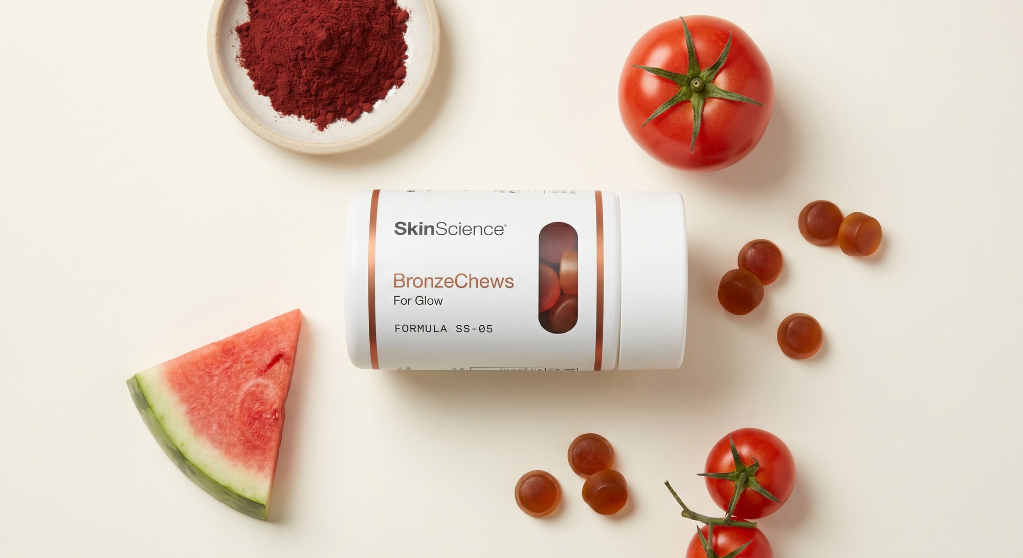 Bronze Protocol flat-lay — bottle + gummies + red microalgae and tomato carotenoid sources